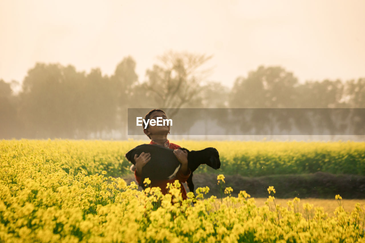 YOUNG WOMAN WITH HORSE IN FIELD