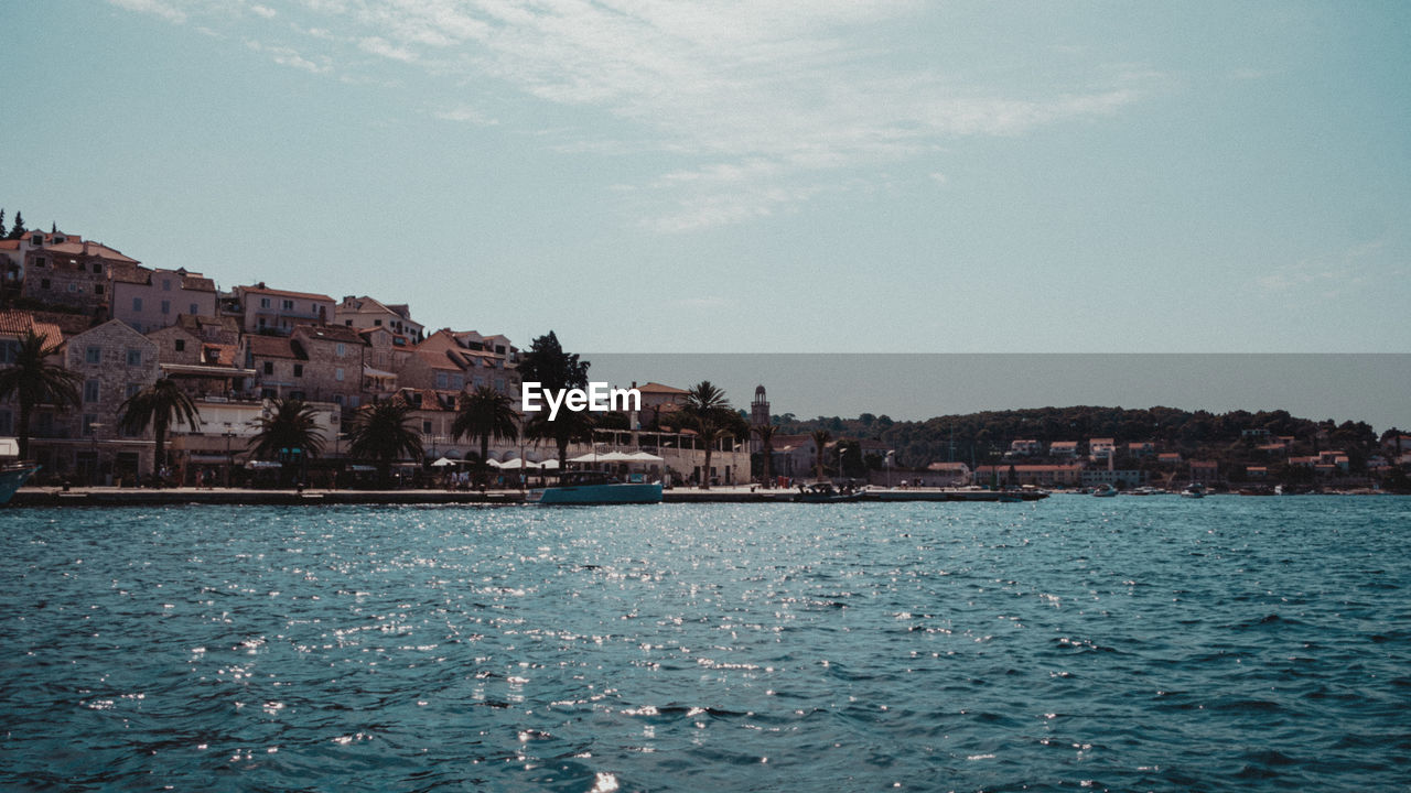 View of town by sea against sky
