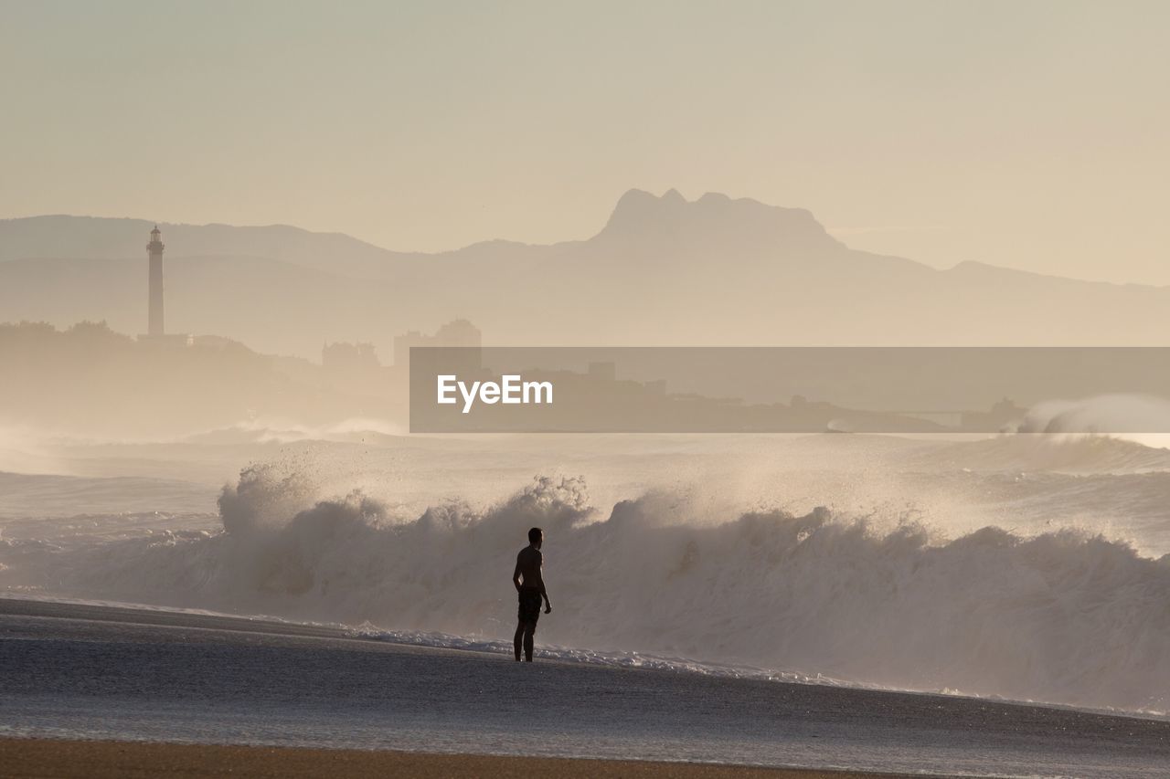 Man standing on beach against sky