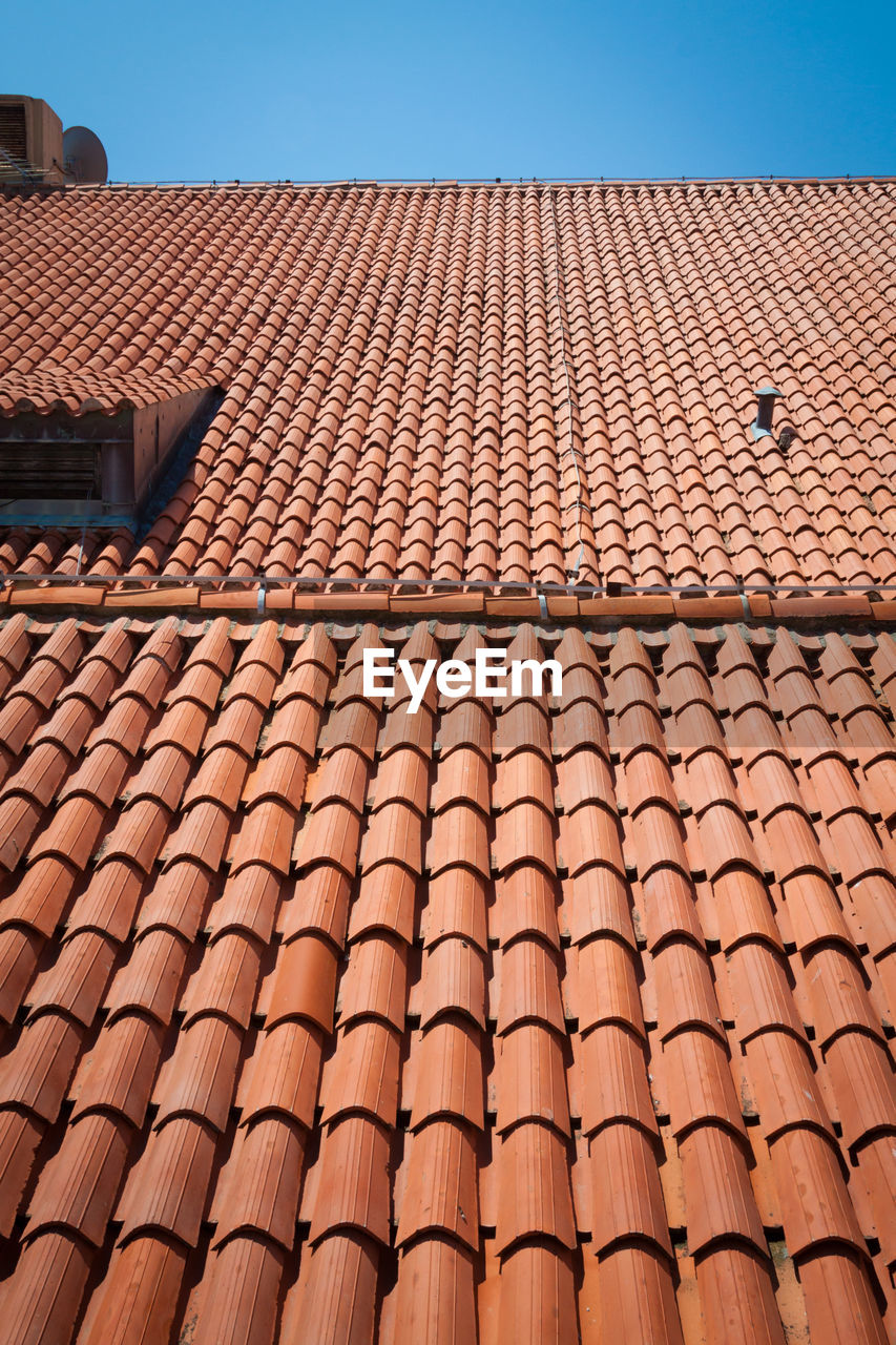 Low angle view of roof tiles against building