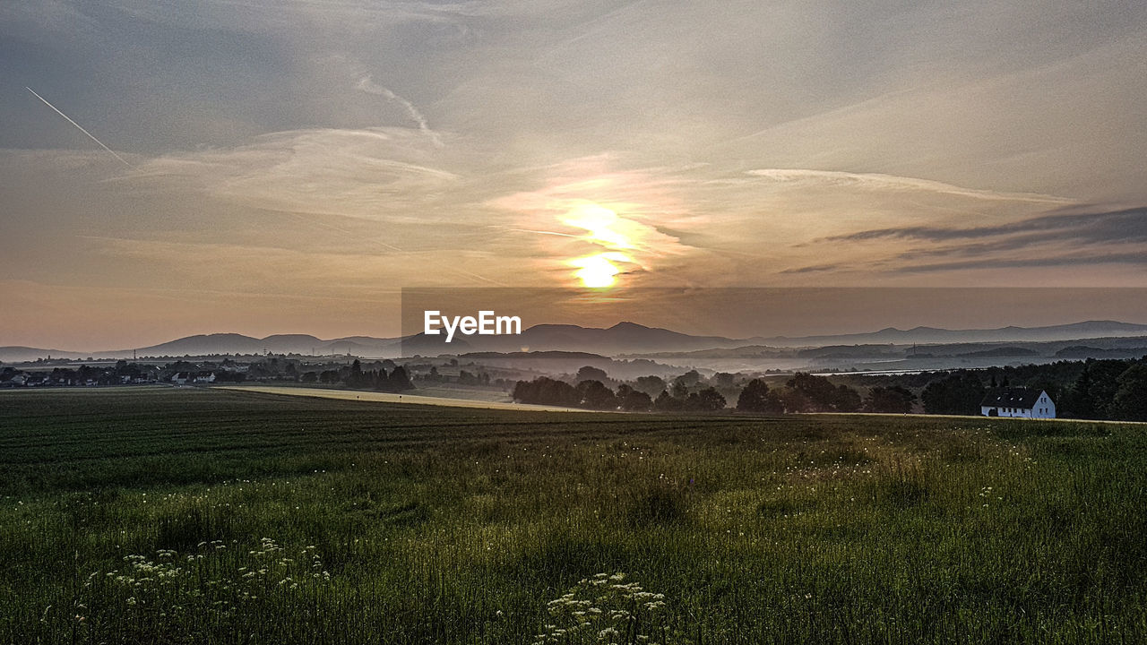 Scenic view of field against sky during sunset