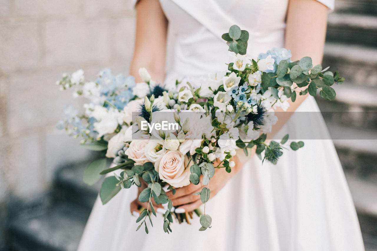 Midsection of woman holding flower bouquet