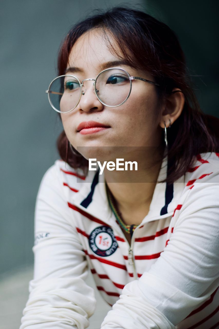 PORTRAIT OF YOUNG WOMAN WITH EYEGLASSES