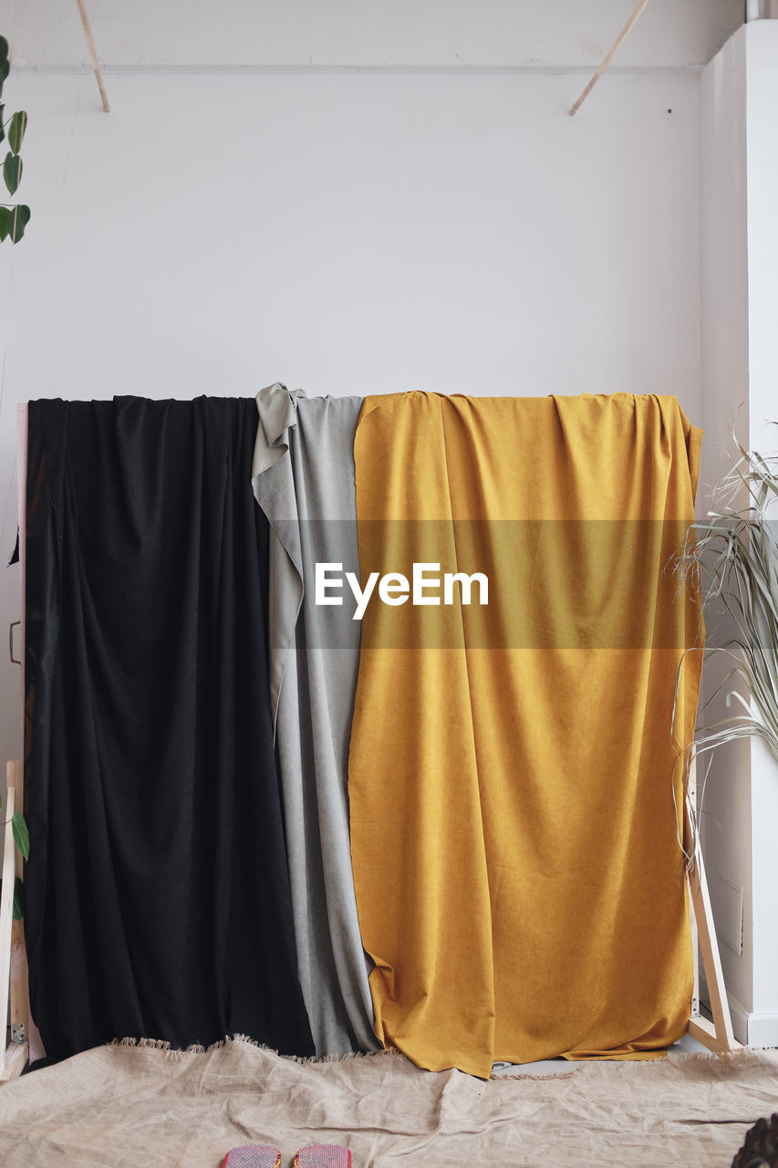 textile, indoors, clothing, no people, interior design, yellow, furniture, hanging, domestic life, home interior, lifestyles, laundry, bed, domestic room, curtain, linen, fashion, wall - building feature, absence