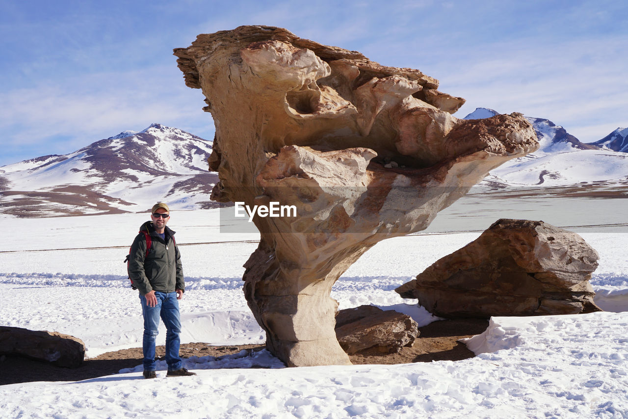 Man standing on snowy field against sky