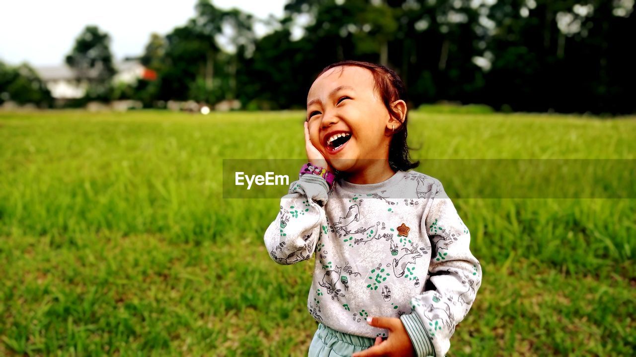 Portrait of cute girl standing on field