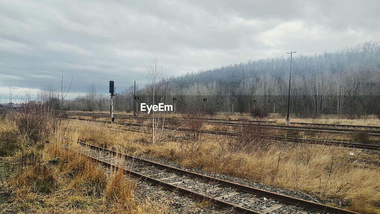 RAILROAD TRACKS BY LANDSCAPE AGAINST SKY