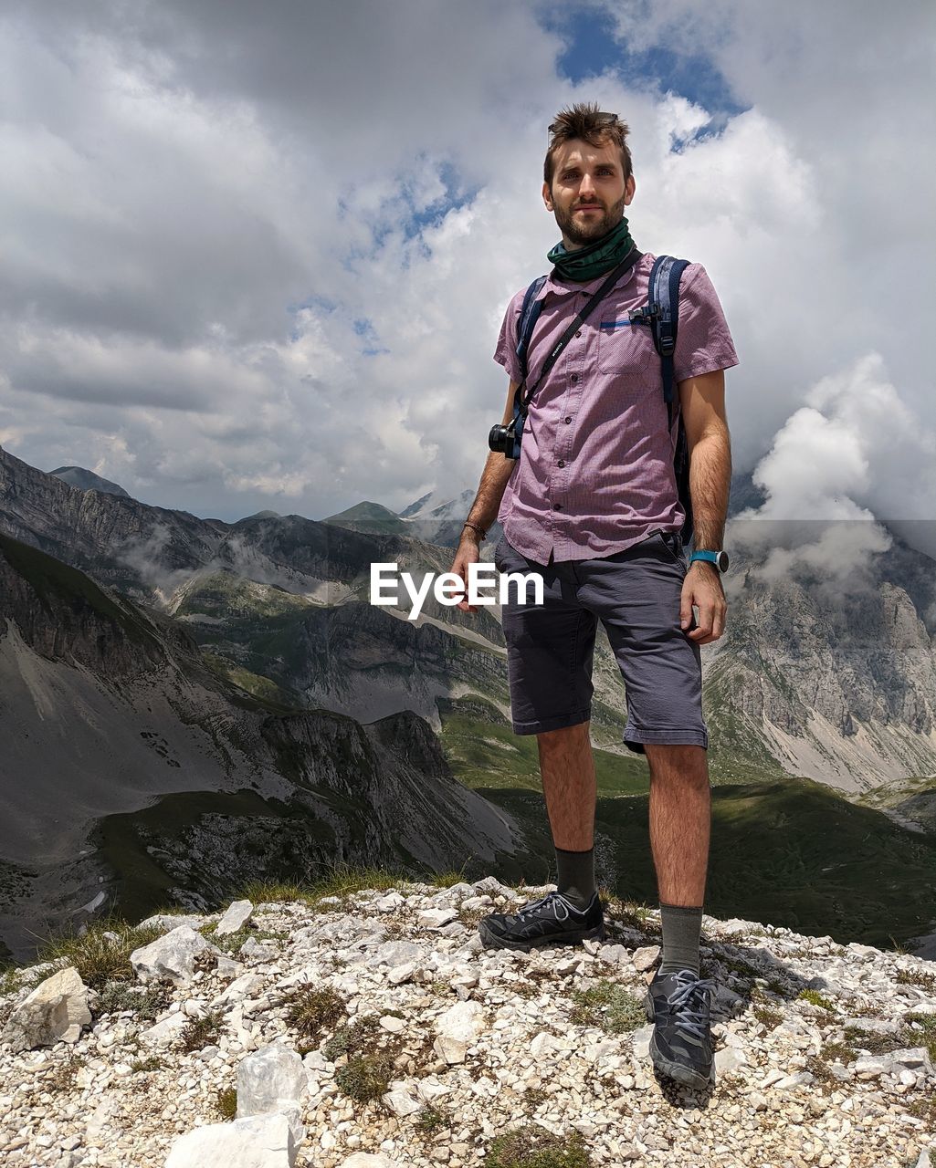 Full length of man standing on mountain against sky