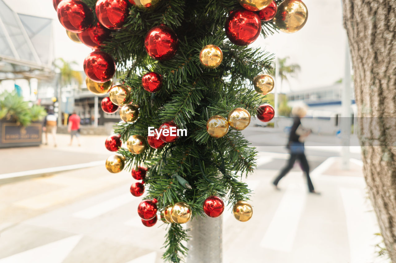 Close-up of christmas decorations hanging on lamp post 