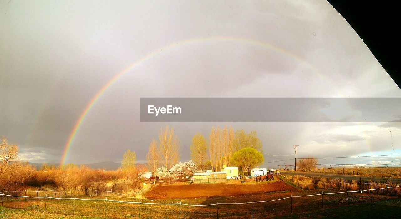 SCENIC VIEW OF RAINBOW OVER FIELD AGAINST SKY