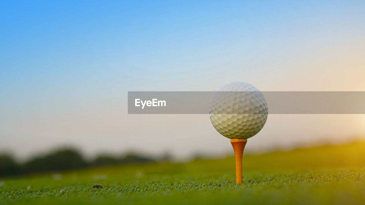 golf ball on grass against sky