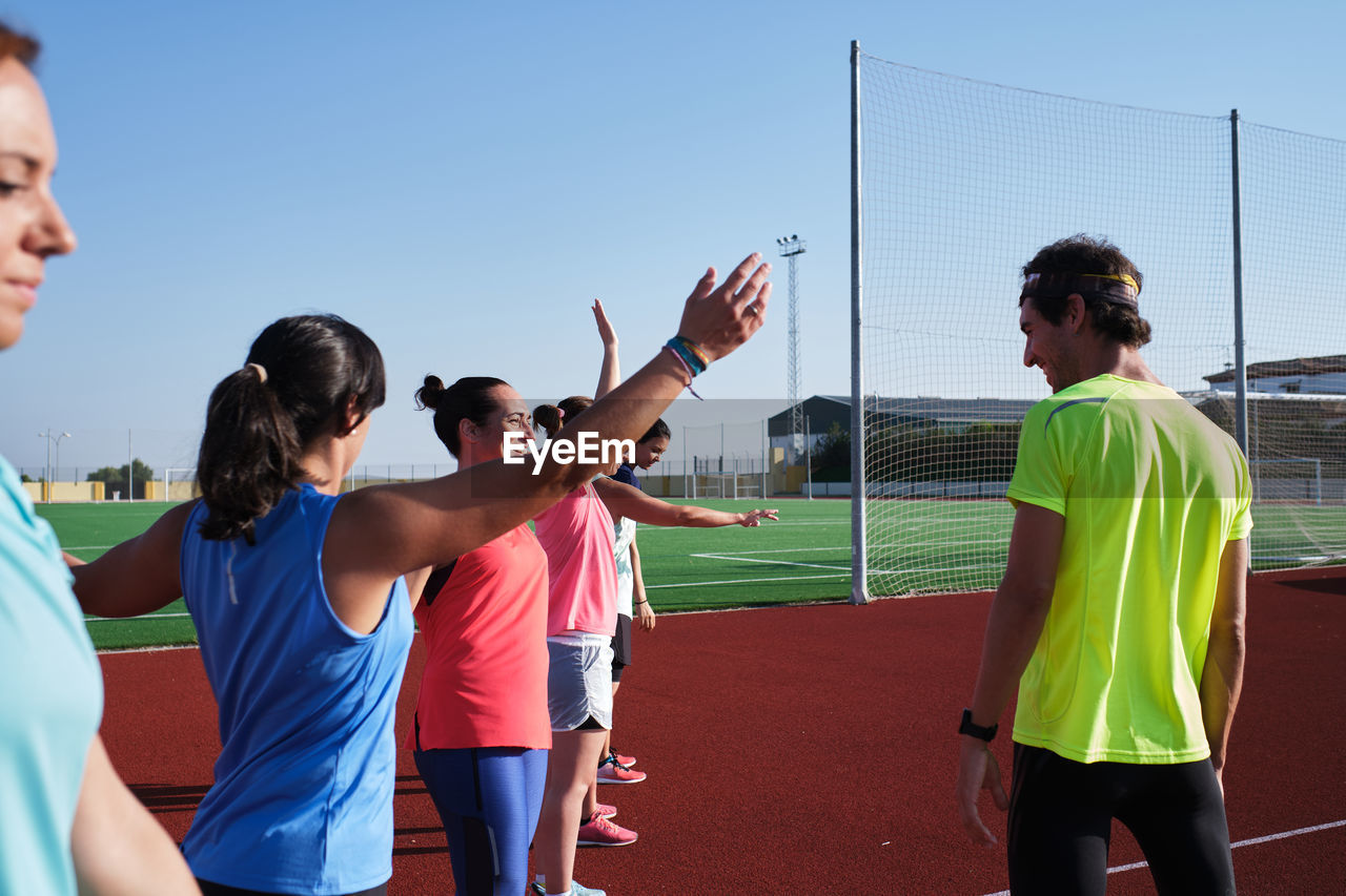 Young women warm up with their coach to start training