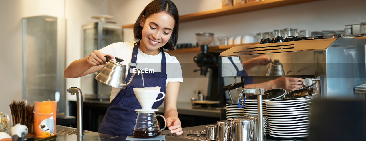 portrait of young woman using mobile phone in cafe