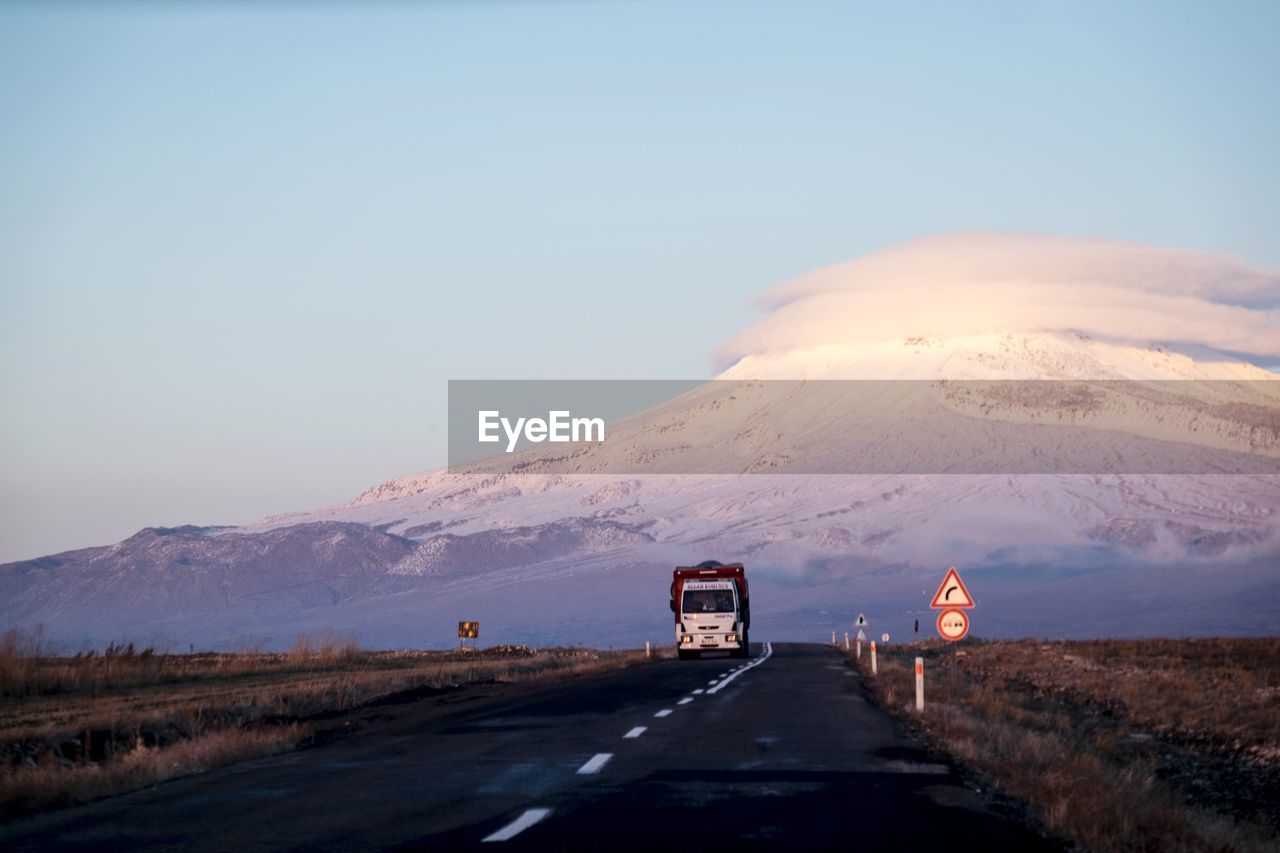 Road leading towards mountain against sky