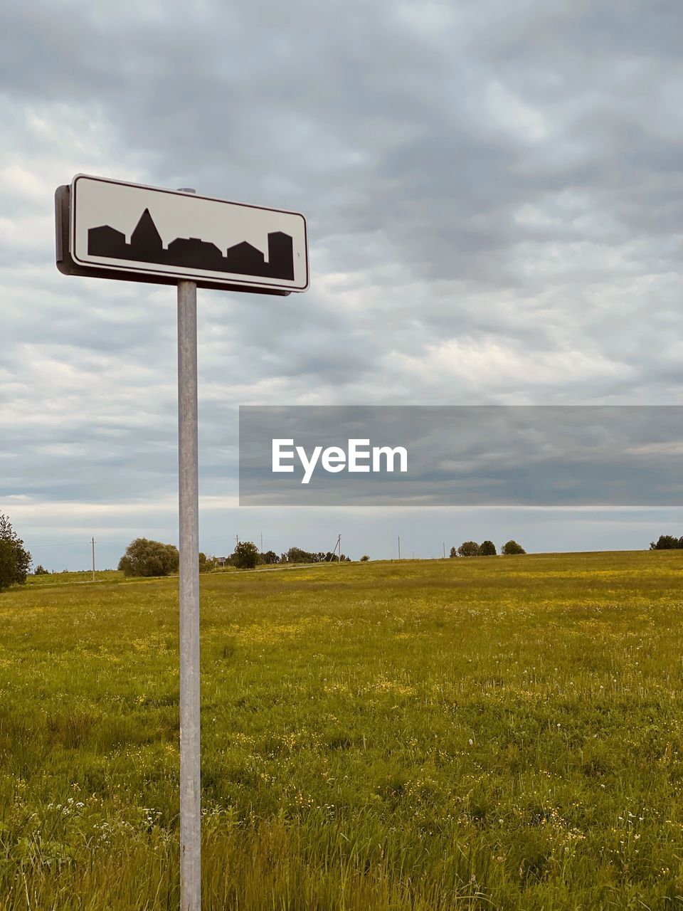 Information sign on field against sky