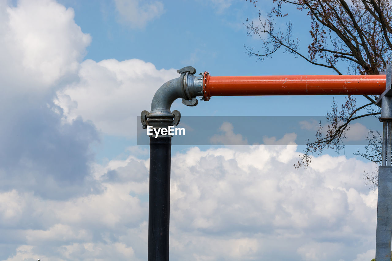 Low angle view of metallic pipe against sky