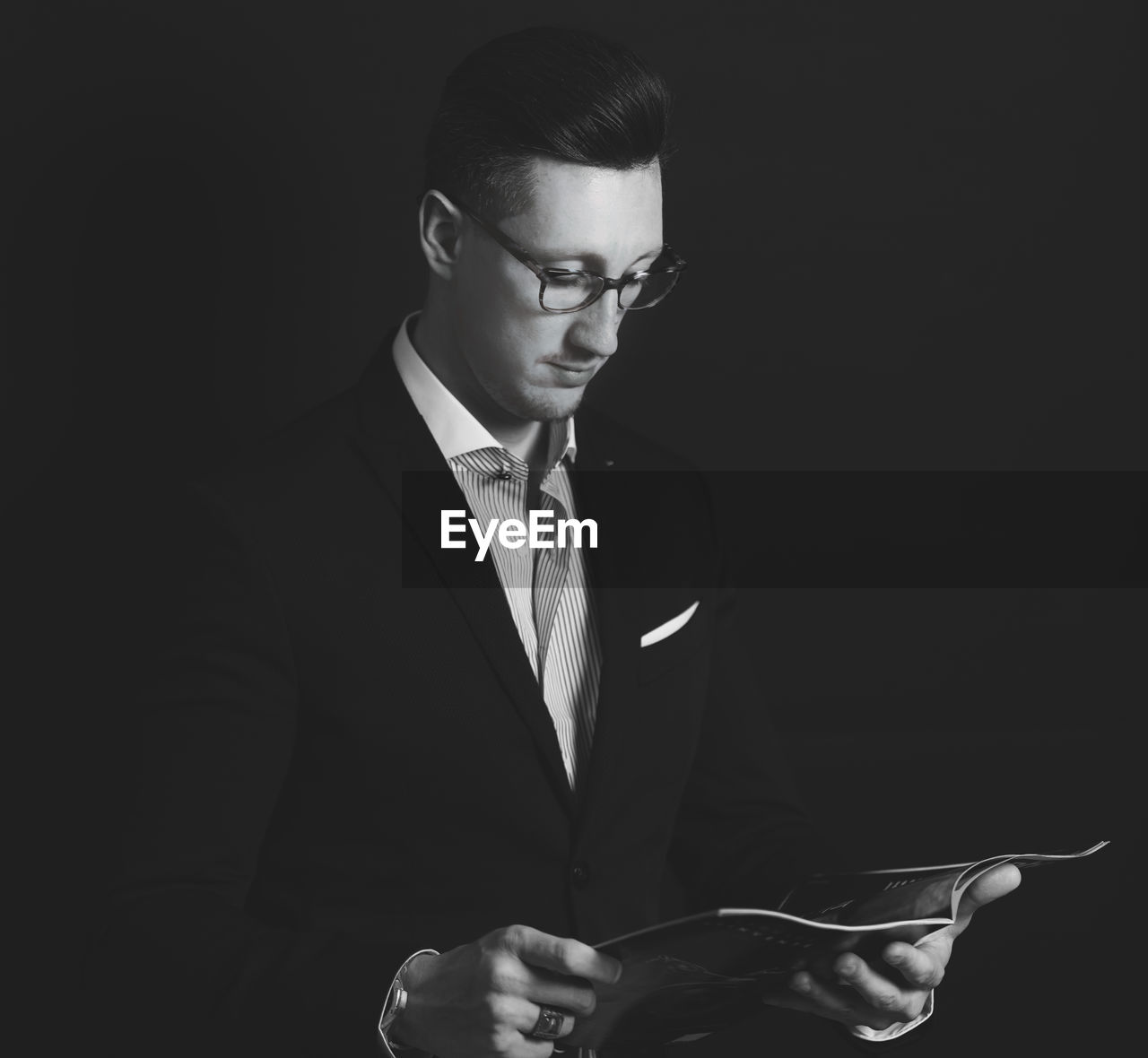 Man reading book against black background