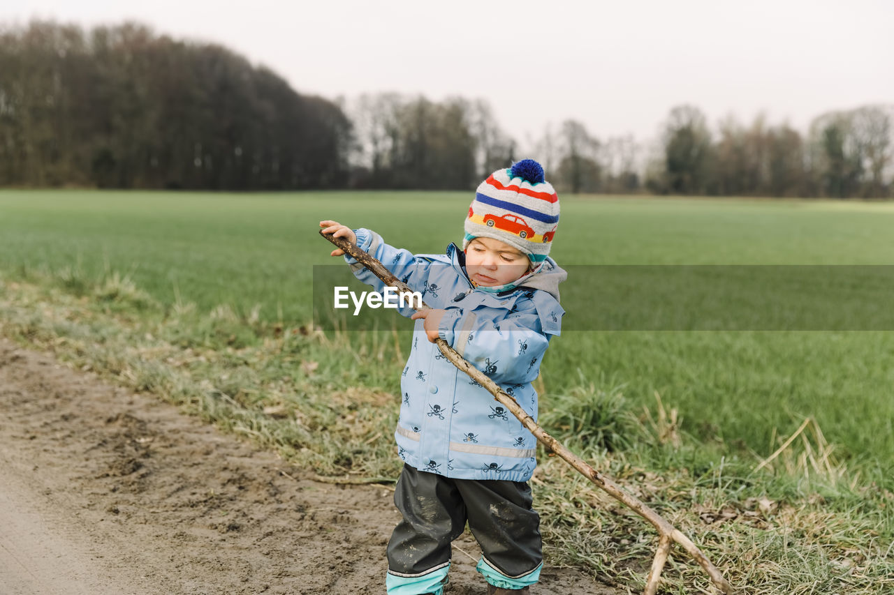 Girl standing on land against field