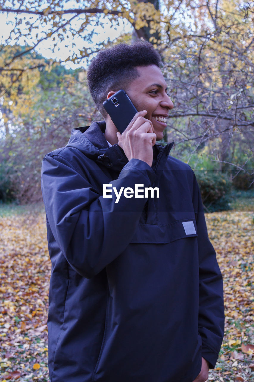 Man talking on phone while standing in forest