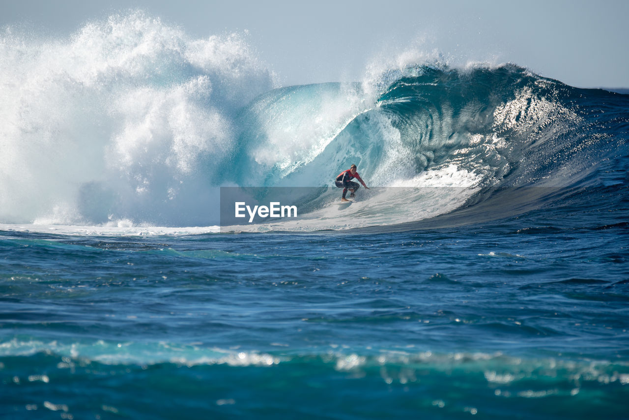 SCENIC VIEW OF SEA BY WAVES AGAINST SKY