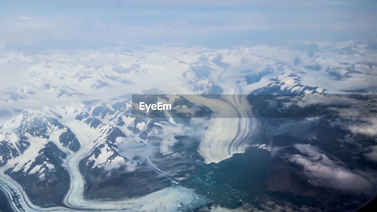 AERIAL VIEW OF SNOWCAPPED MOUNTAINS AND SEA