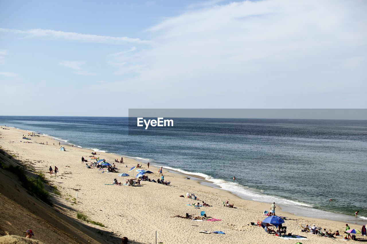 People at beach against sky