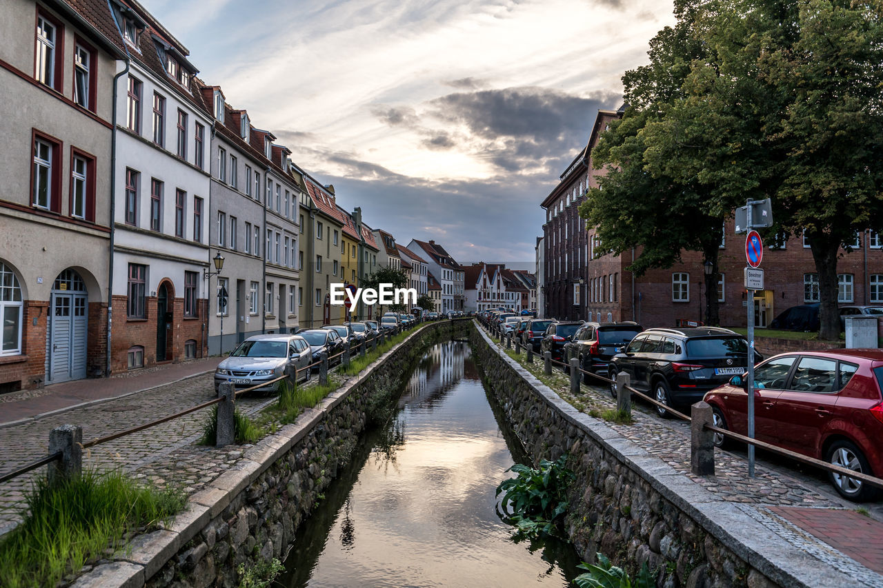 CANAL AMIDST BUILDINGS AGAINST SKY