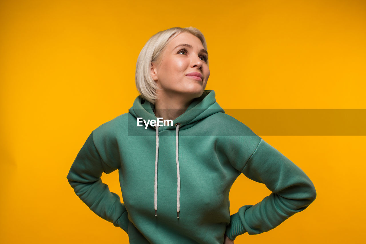 PORTRAIT OF A WOMAN AGAINST YELLOW BACKGROUND