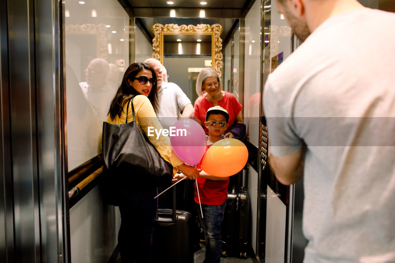 Family looking at man while standing in elevator