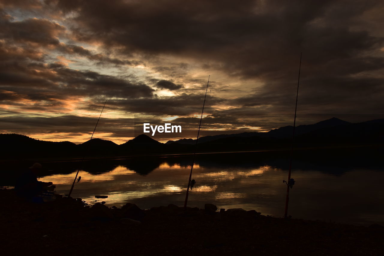 SCENIC VIEW OF LAKE AGAINST DRAMATIC SKY