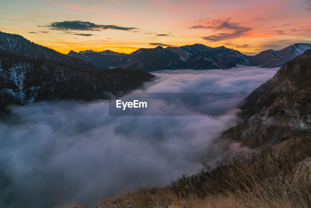 Scenic view of snowcapped mountains against sky during sunset