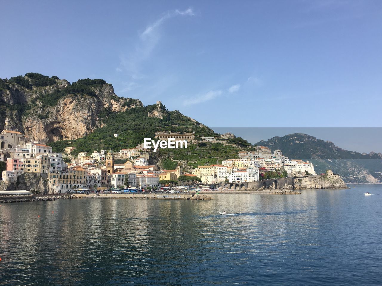 Buildings on mountain by river against sky at amalfi coast