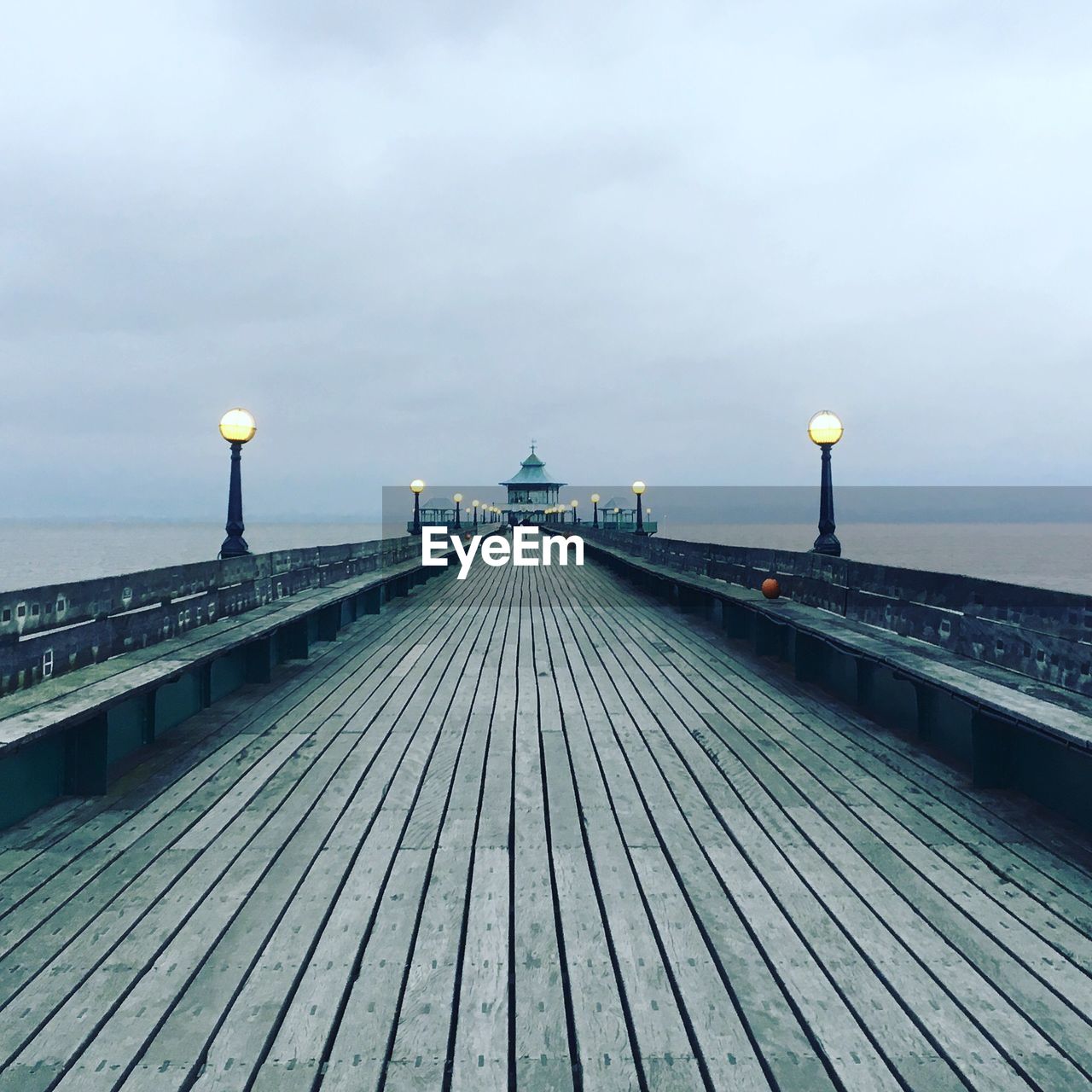 View of pier on sea against cloudy sky