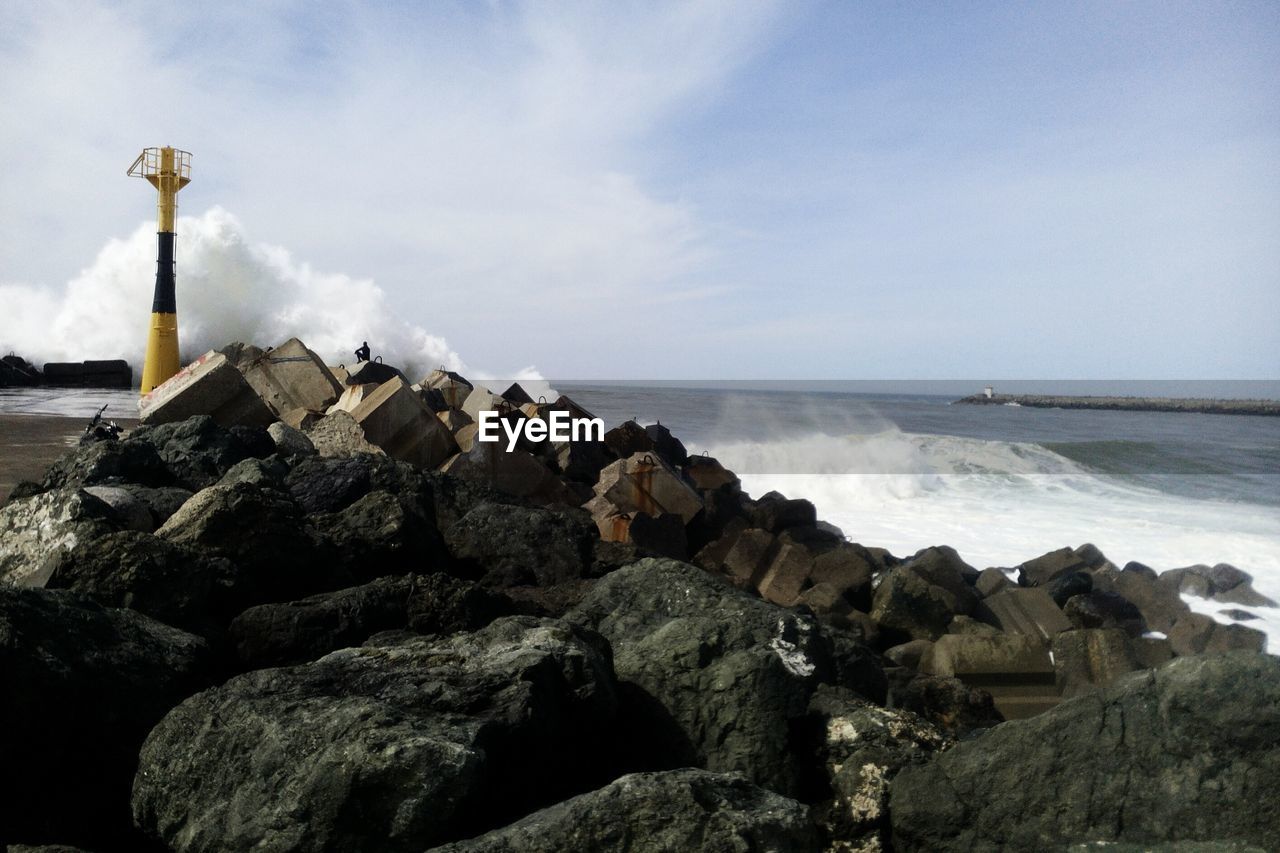 Scenic view of rocks on beach against sky