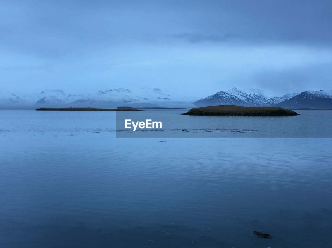 Scenic view of calm sea against cloudy sky