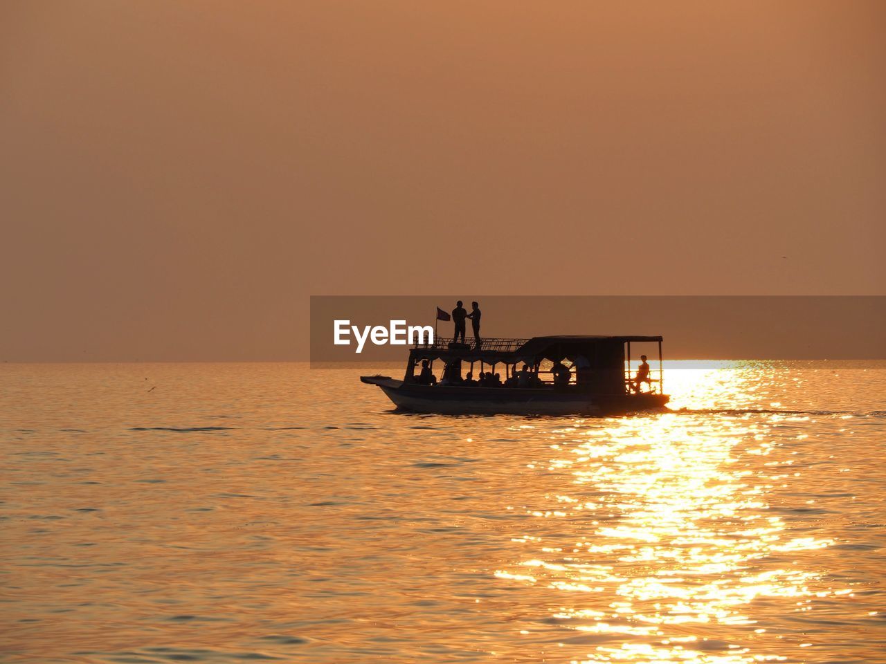 SILHOUETTE SHIP SAILING IN SEA AGAINST SKY DURING SUNSET