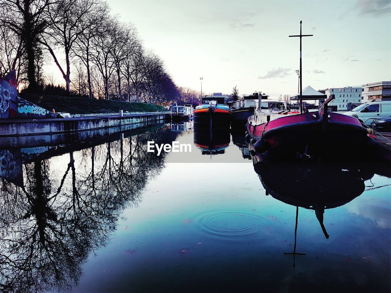 BOATS MOORED ON RIVER AGAINST SKY