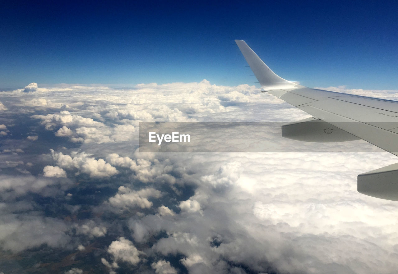 AERIAL VIEW OF AIRPLANE WING OVER CLOUDS