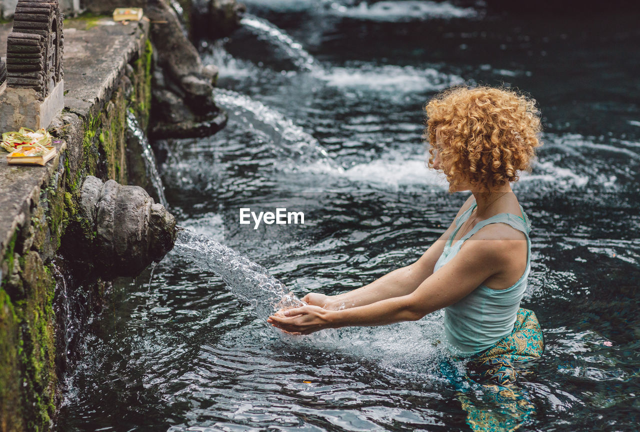 Side view of woman standing in water