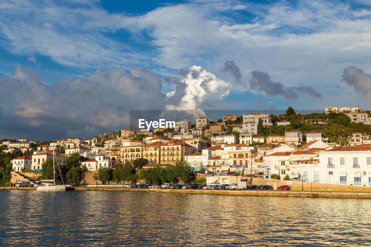 RIVER BY TOWNSCAPE AGAINST SKY