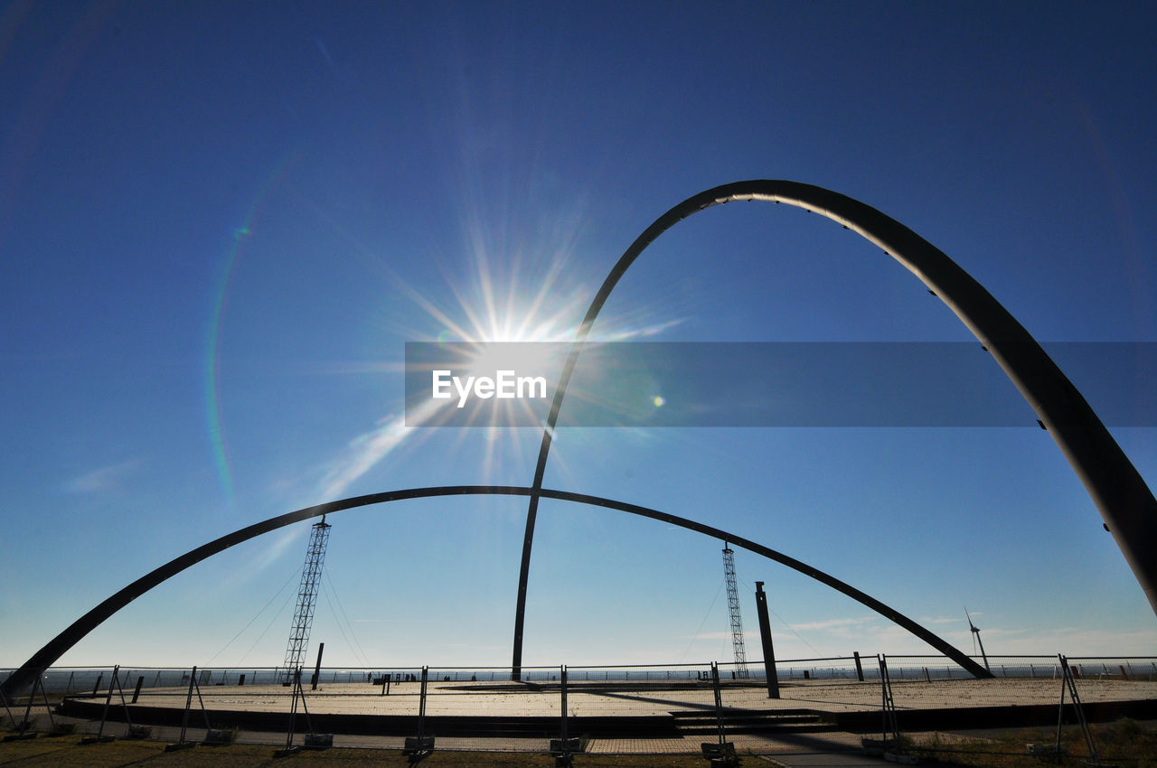 LOW ANGLE VIEW OF FOOTBRIDGE AGAINST CLEAR BLUE SKY