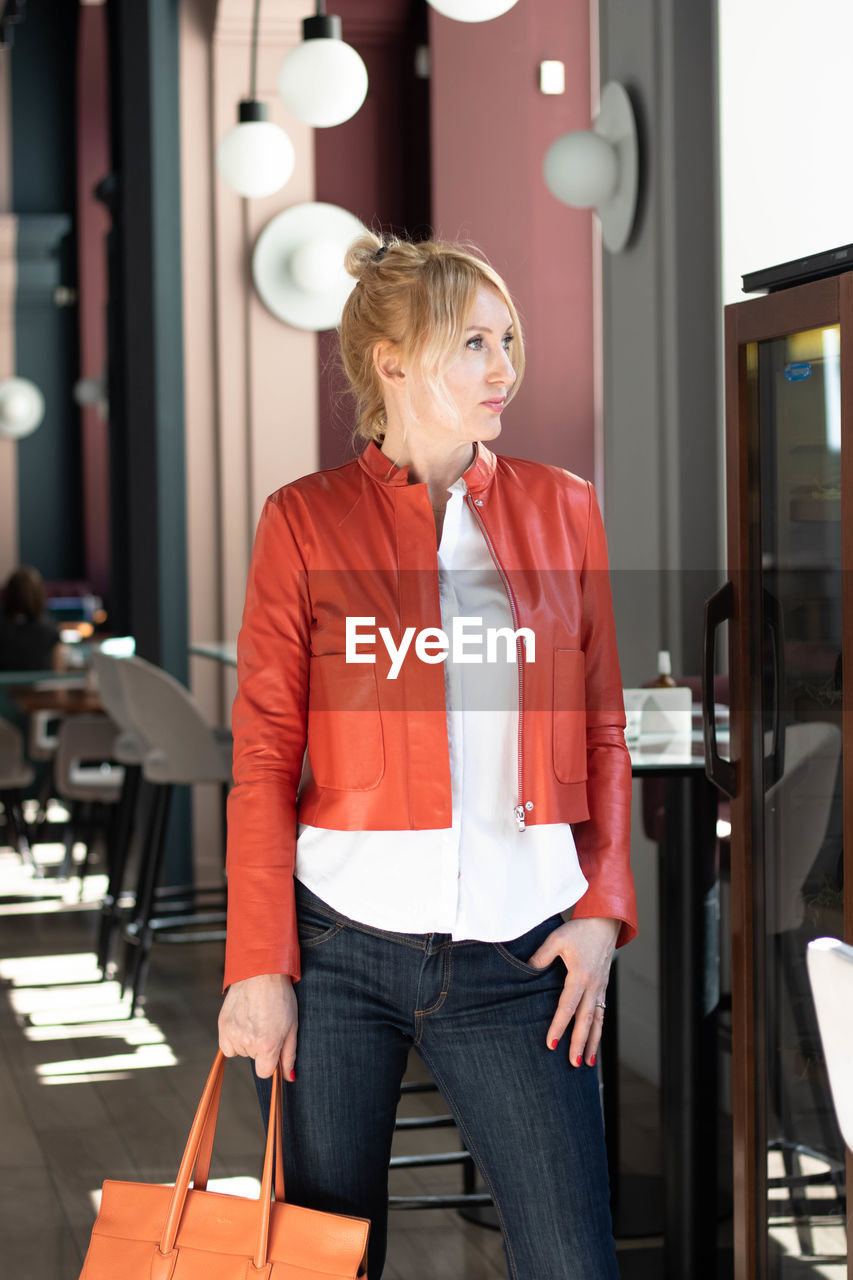 Beautiful woman looking away while standing in office