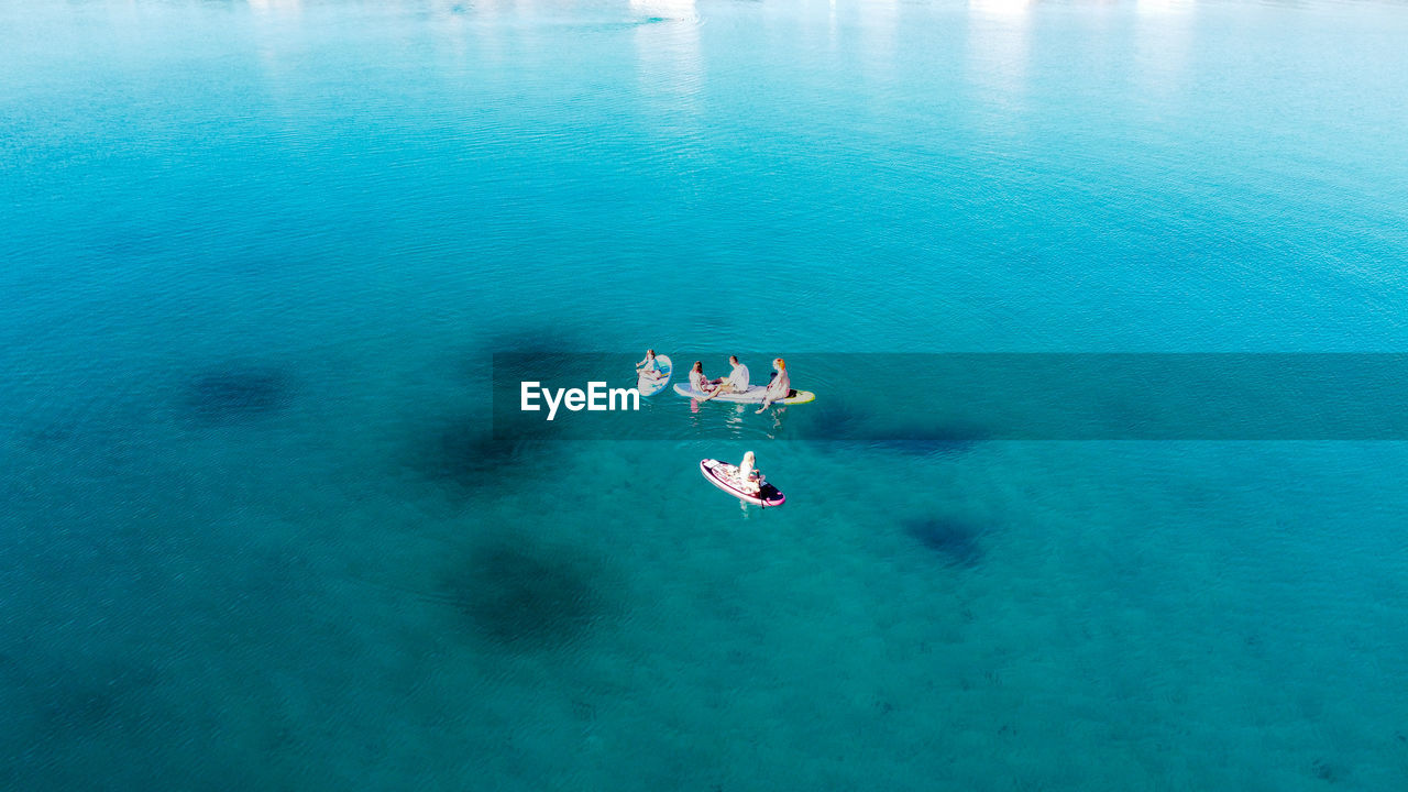 HIGH ANGLE VIEW OF PEOPLE ON SEA