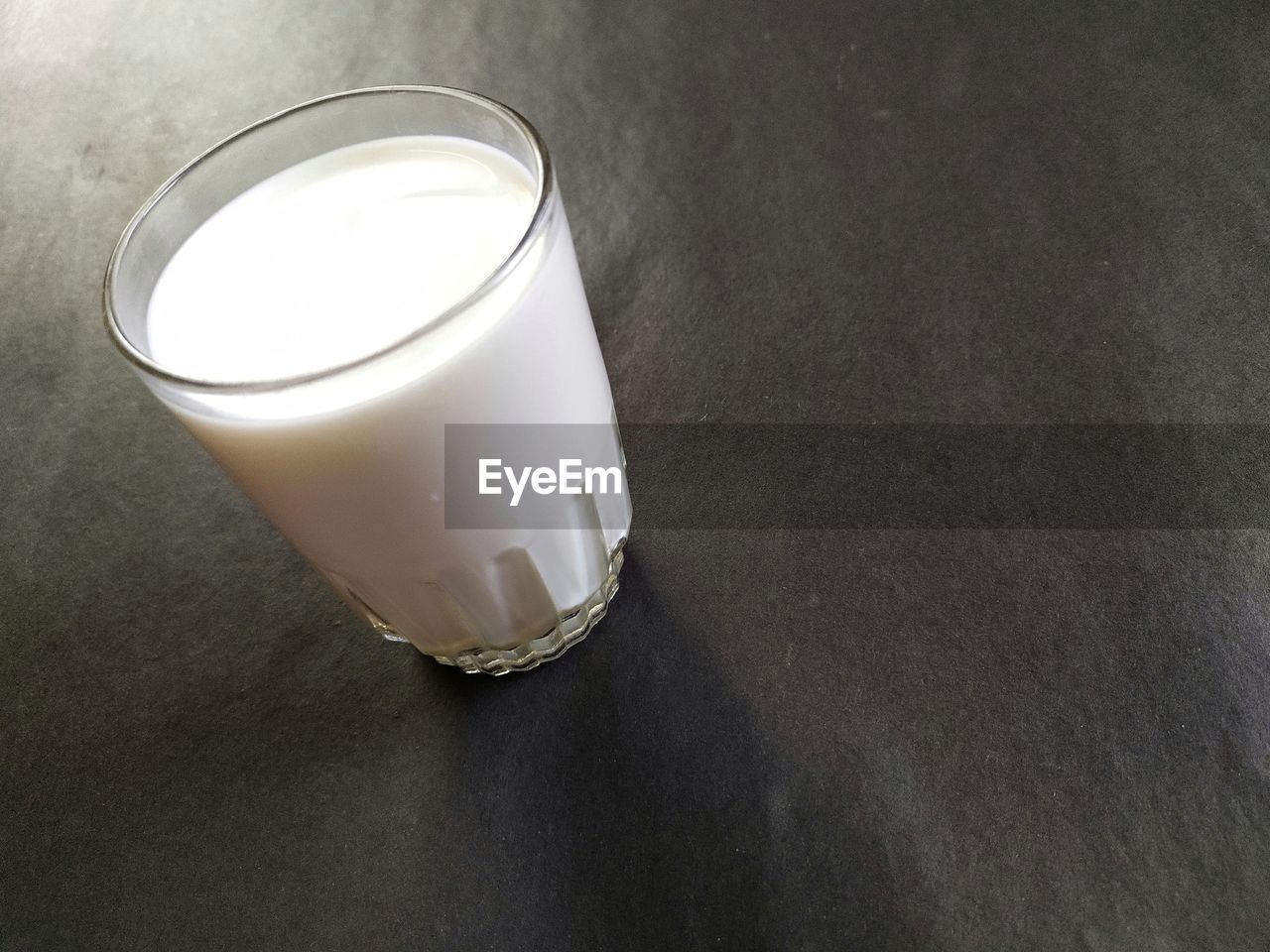 HIGH ANGLE VIEW OF TEA CUP ON GLASS TABLE