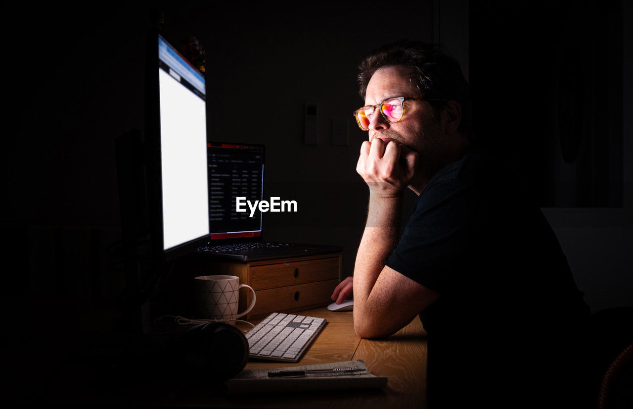 Man using computer at home at night