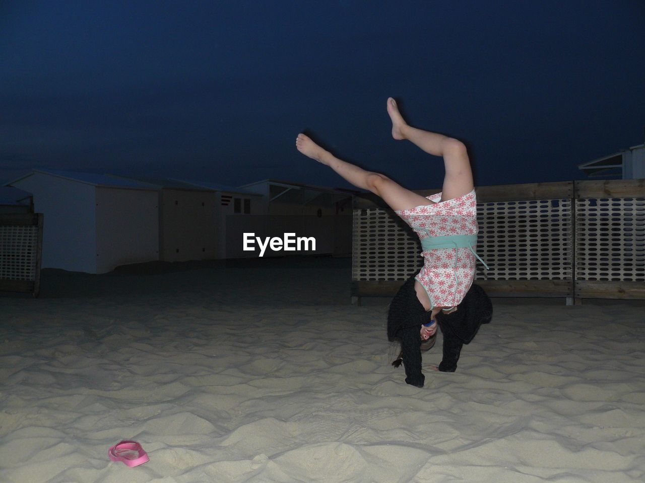 Full length of woman with handstand against sky at night