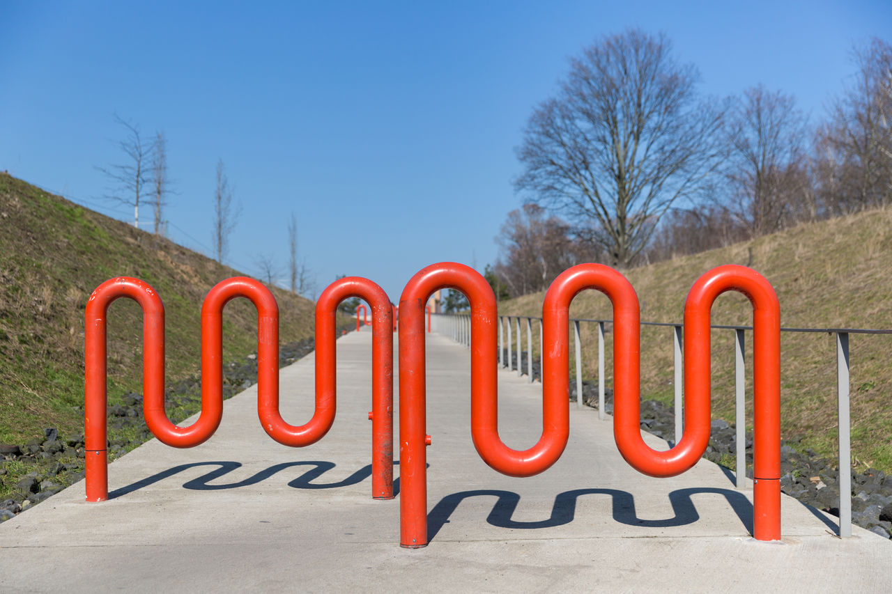 Metallic barriers on street against sky