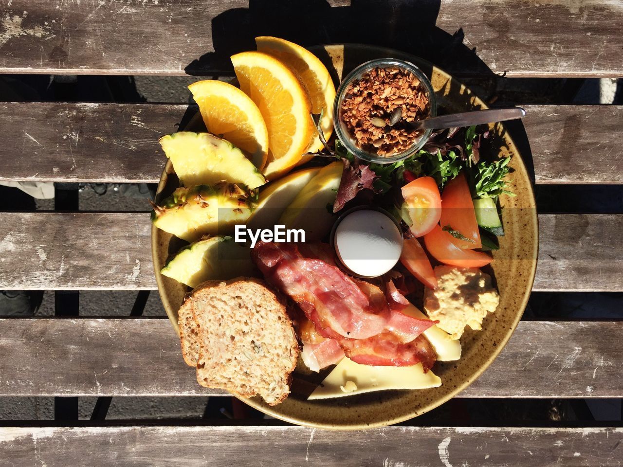 Directly above shot of food in plate on wooden table during sunny day