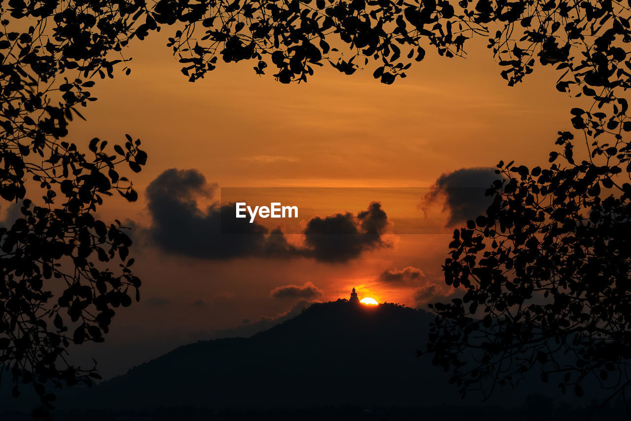 Scenic view of silhouette mountains against orange sky