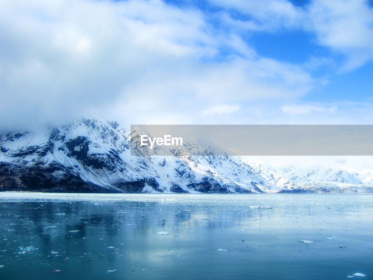 Scenic view of ice covered lake and snow capped mountains 